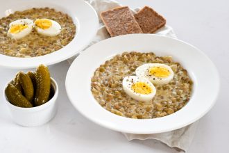 Čočka se zakysanou smetanou, vajíčkem a kyselým okurkem.