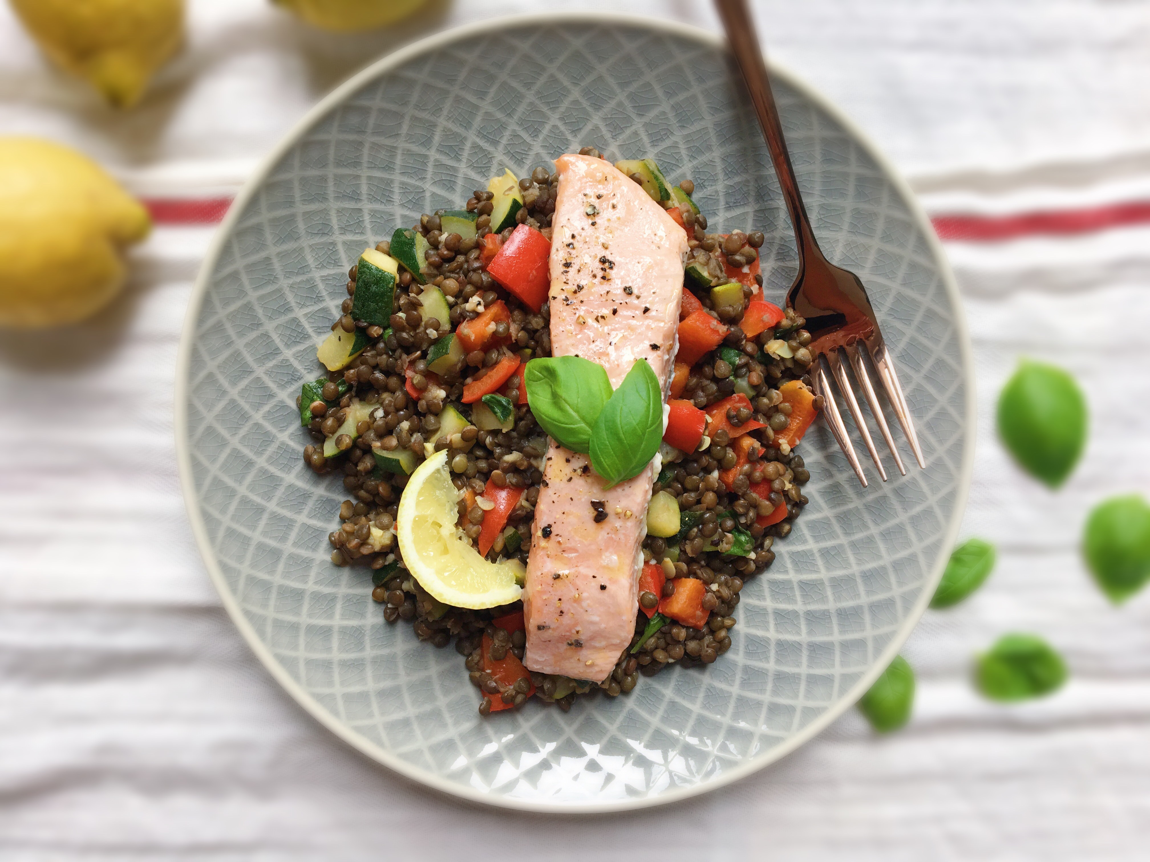 Teplý salát z čočky beluga s červenou paprikou a cuketou a s pečeným lososem. Zdravé recepty. Zdravé jídlo. Čerstvá bazalka.