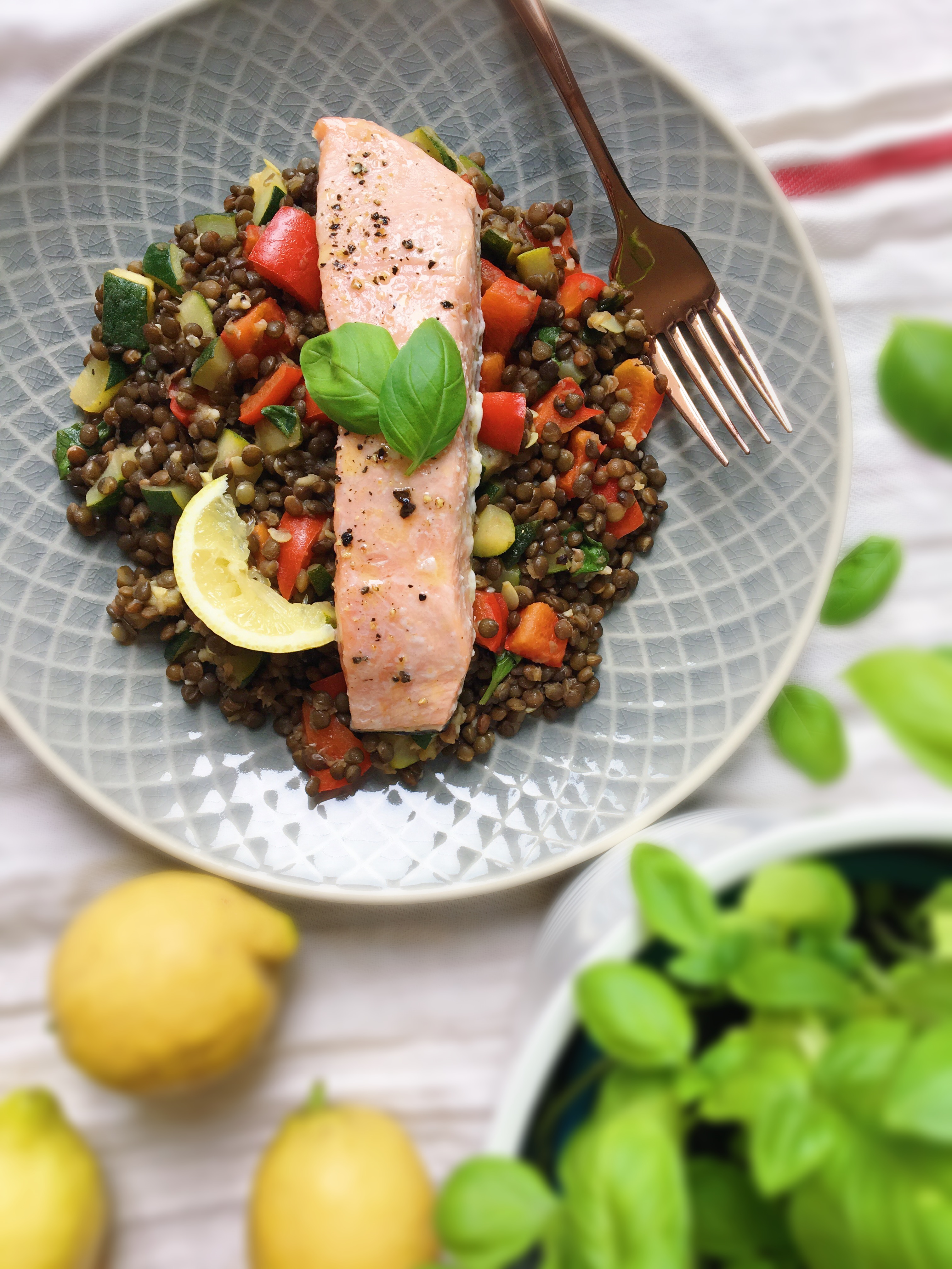 Teplý salát z čočky beluga s červenou paprikou a cuketou a s pečeným lososem. Zdravé recepty. Zdravé jídlo. Čerstvá bazalka.