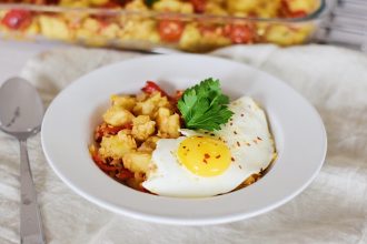 Pečená zelenina s červenou čočkou. Pečené brambory, rajčata, cibule a červená paprika v pekáči. Volské oko. Smažené vajíčko.