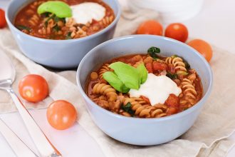 Těstovinová polévka. Tomatová polévka s celozrnnými těstovinami, špenátem a zakysanou smetanou. Čerstvá bazalka. Sytá polévka. Zdravé recepty.