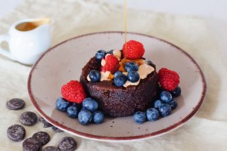 Zdravý čokoládový mug cake s ovocem, arašídovým máslem a politý javorovým sirupem. Veganský.